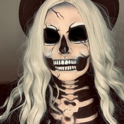 Woman with skull makeup applied to face and chest