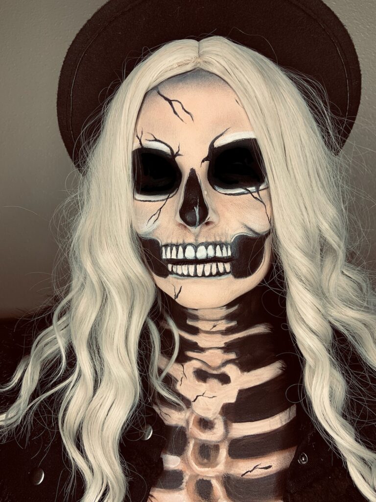 Woman with skull makeup applied to face and chest