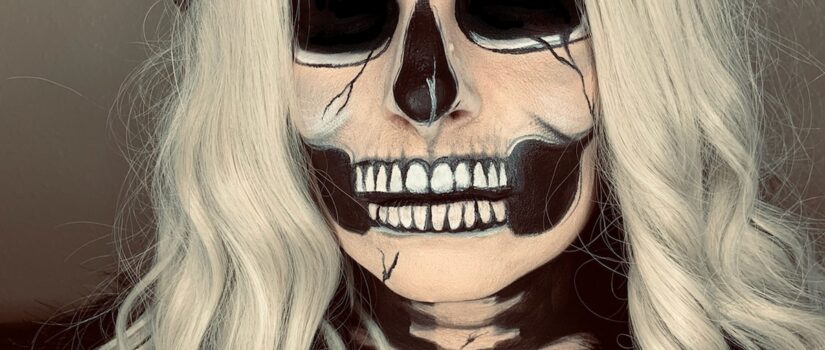 Woman with skull makeup applied to face and chest